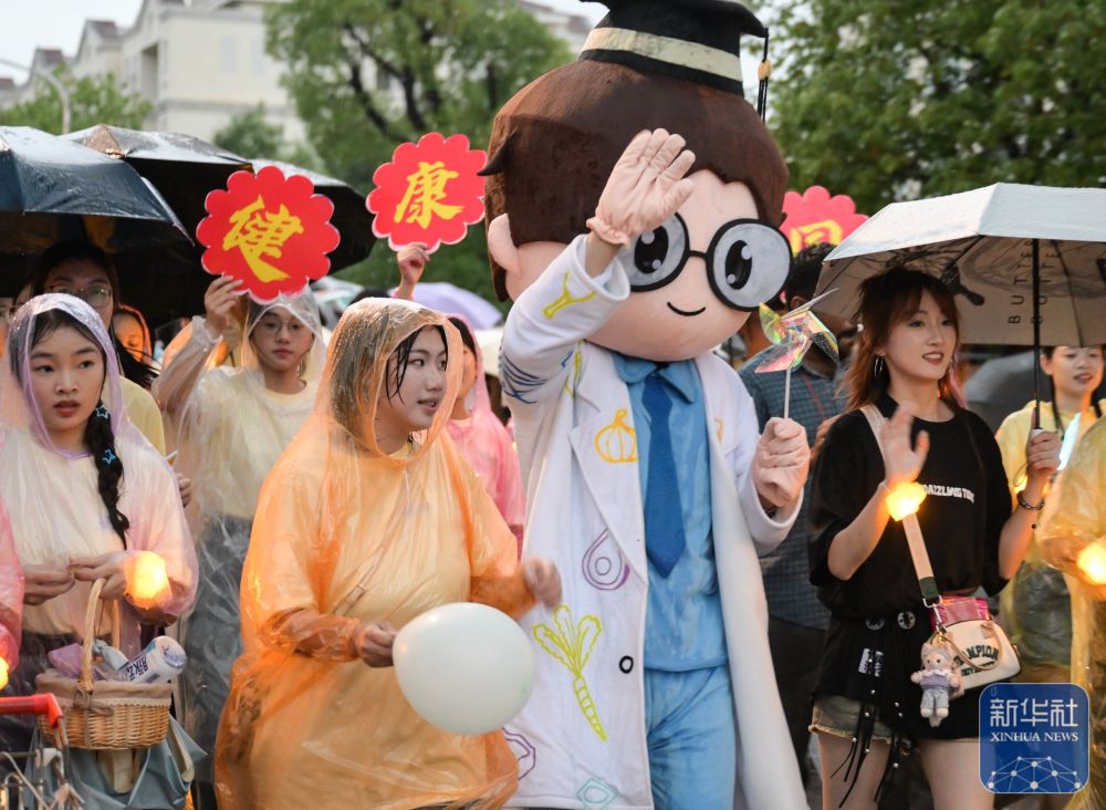 6月21日，yl6809永利官网学生在校园里冒雨巡游。2